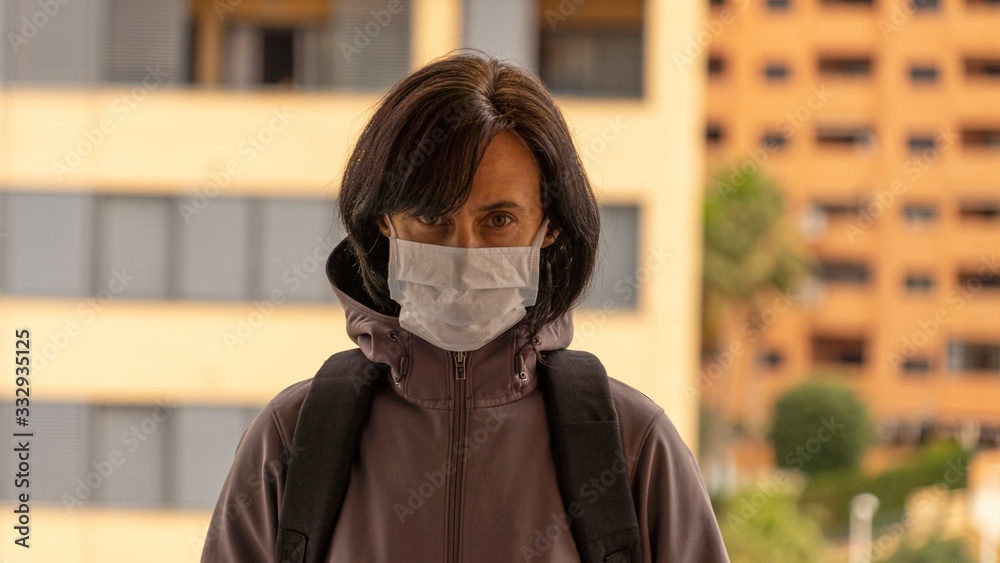 Woman wearing medical protective mask in the city outdoors. Health protection during flu virus outbreak, coronavirus epidemic infectious diseases