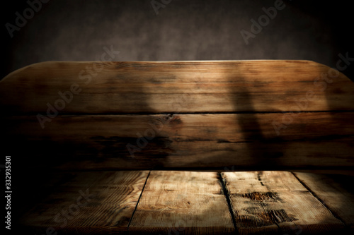 Wooden desk of free space and dark mood background.