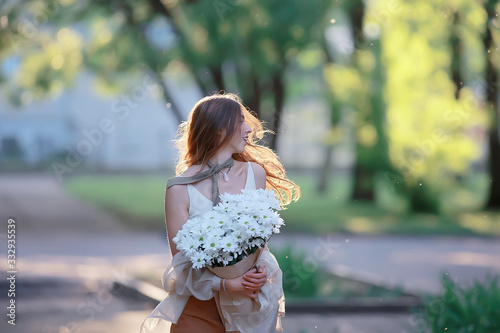 girl holding a bouquet of flowers a walk in the park / romantic young beautiful cute model, love feelings gift