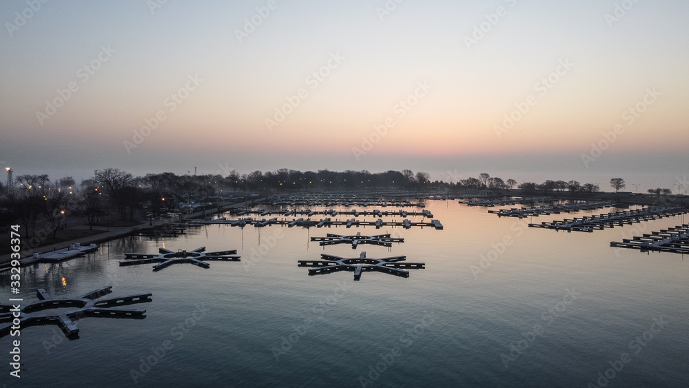 Straight on overhead shot of empty boat docks in calm lake inlet on colorful morning in Chicago Illinois