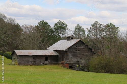 old vintage riverbank country farm barn building sunny cloudy sky