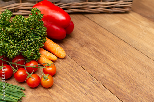 Fresh vegetables lie on the board on the background of the basket