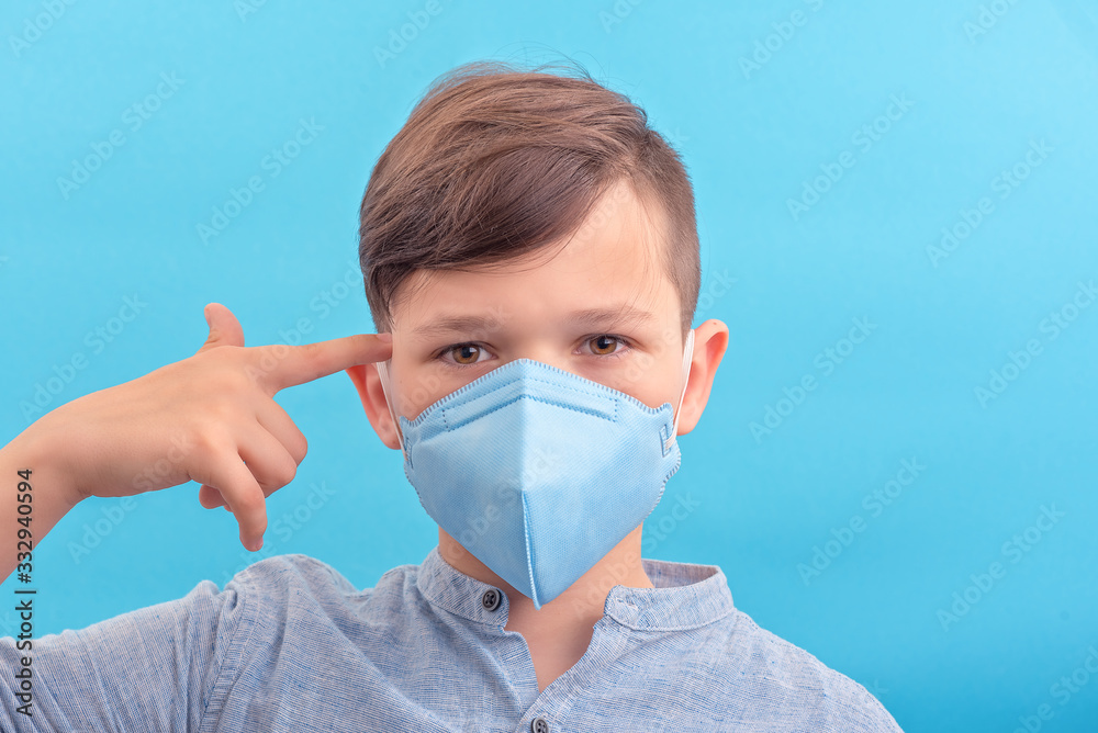 Handsome brunette boy in medicine face mask showed think about protection be responsible Handsome brunette boy in medicine face mask showed think about protection be responsible