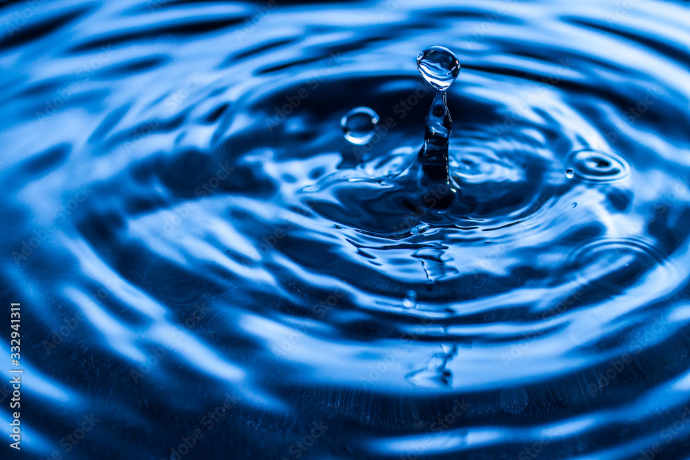 water drop splash in a glass blue colored water drop splash in a glass blue colored