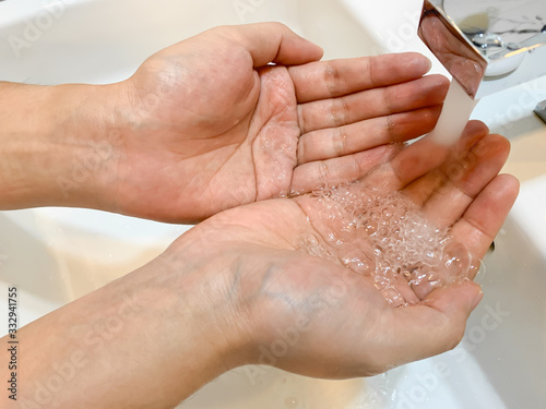 Washing hand with water under the faucet, without soap, hygiene concept, washing hand for prevention of corona virus