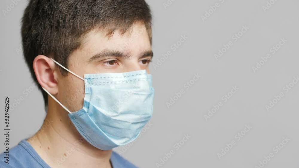 serious young doctor in protective medical mask thinking on gray studio background, concept medicine and hope,specialist concentrated on searching solution serious young doctor in protective medical mask thinking on gray studio background, concept medicine and hope,specialist concentrated on searching solution