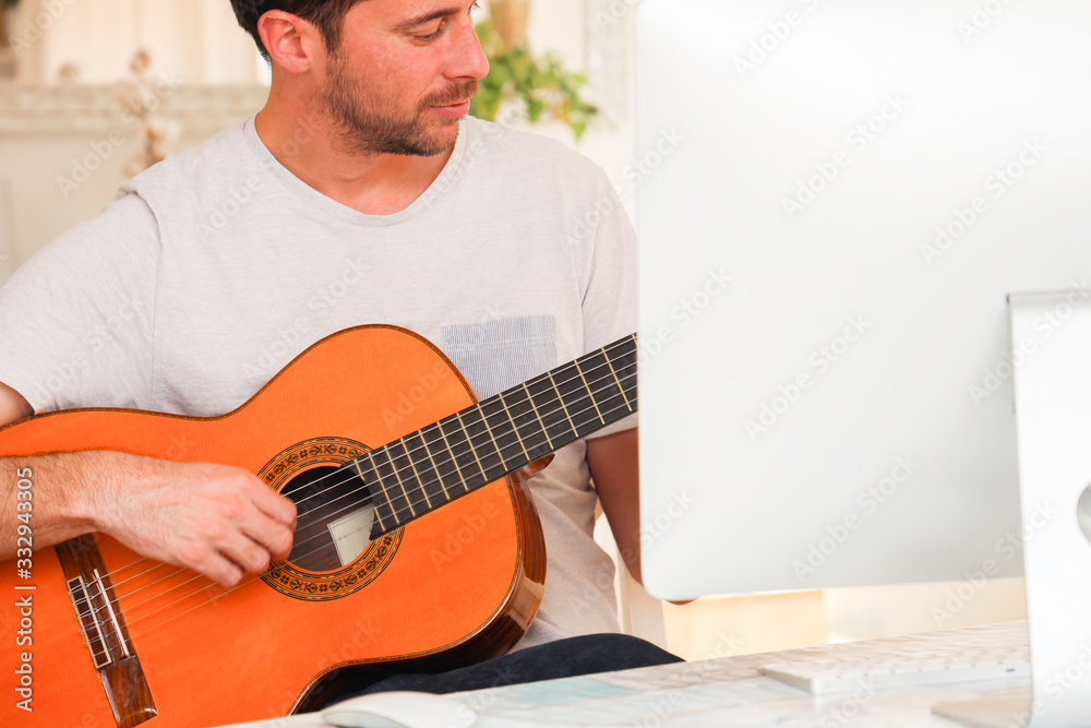 Obraz premium Model learning online how to play guitar by himself.