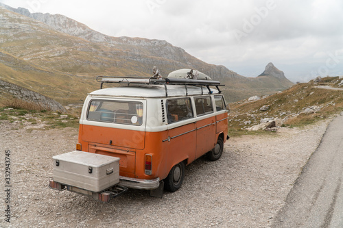 White-orange minibus standing on the side of a mountain road