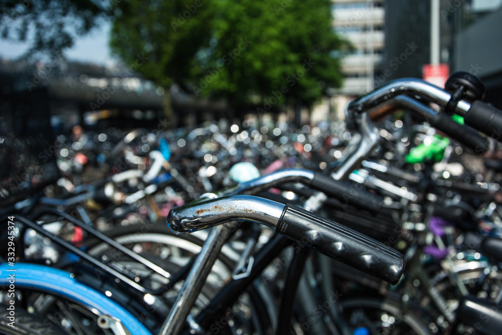 Bicycle parking in Amsterdam, Netherlands. Metal handlebar. Environmental transport. Bicycle parking in Amsterdam, Netherlands. Metal handlebar. Environmental transport.