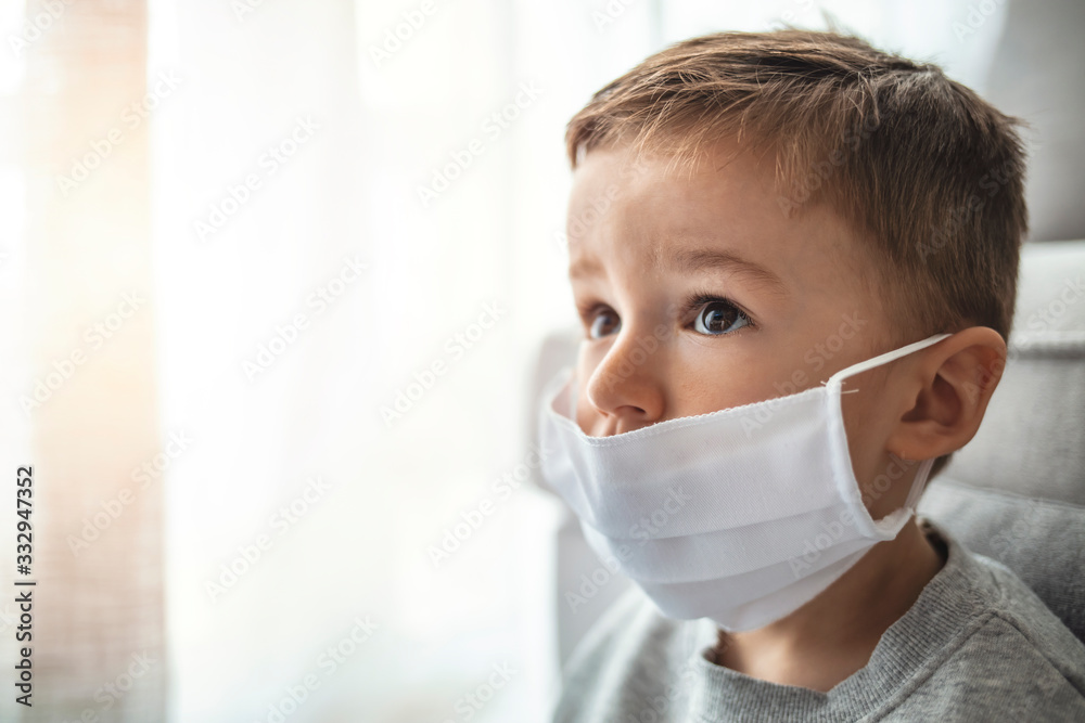 Toddler boy with medical mask on the face. Covid 2019 corona virus outbreak. Sad child isolated on white. Boy at home. Little boy trying to stay healthy by wearing a mask Toddler boy with medical mask on the face. Covid 2019 corona virus outbreak. Sad child isolated on white. Boy at home. Little boy trying to stay healthy by wearing a mask