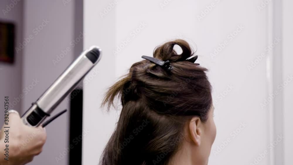 Close up slow motion of a beautiful woman at the hairdresser. Long curls Close up slow motion of a beautiful woman at the hairdresser. Long curls