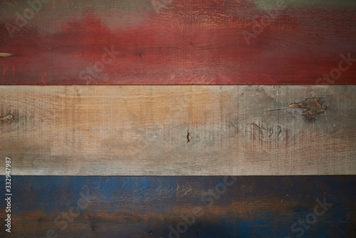 Wooden shield, which is formed by boards. Boards are painted in different colors, namely blue, orange, brown. Background