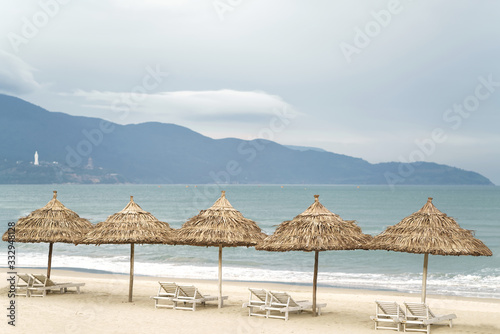 Palm shelters with sunbeds in China Beach in Da Nang © Roman Babakin