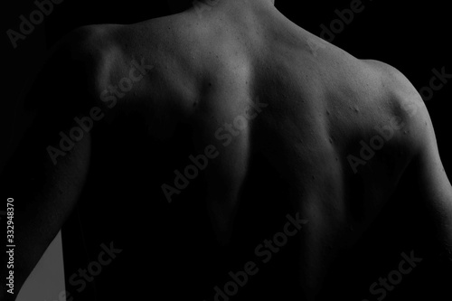 Back. The back of the man. Man holding a chain on his back in both hands. Chain. Black and white photo. Power. Sports Hall.