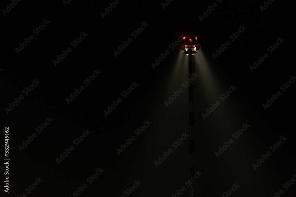 Light mast. Lighting at the airport. Light in the dark. Light beam in the fog on a black background.