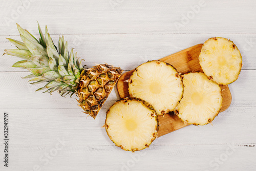 Ripe pineapple cut on slices on wooden background