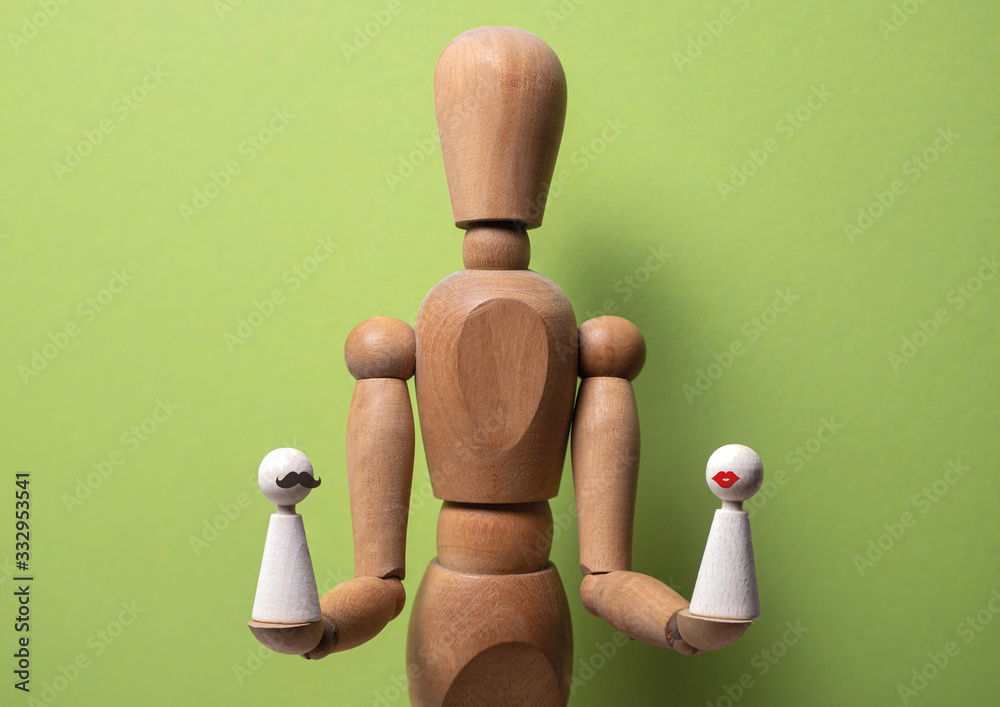 Concept of marriage mediator. Wooden dolls on green background