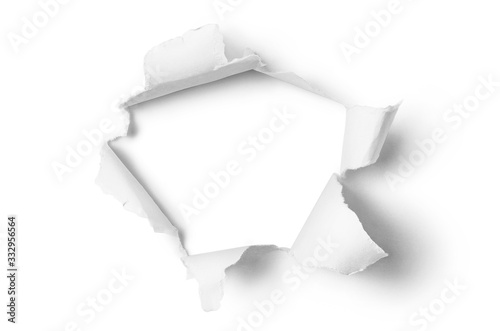 Ragged hole torn in ripped paper, isolated on white background photo