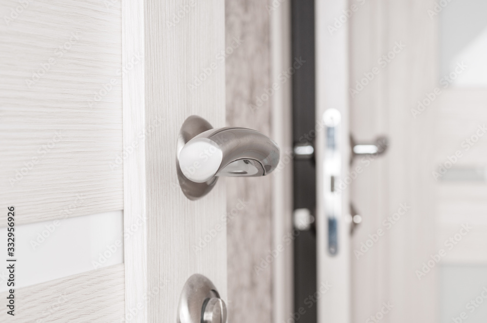 Metallic door handle on a wooden door close up Metallic door handle on a wooden door close up