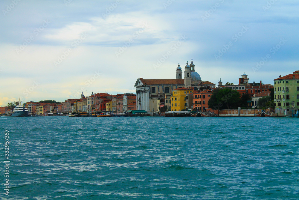 Traditional street view in Venice, Italy. Panorama of Venice in the evening. Old houses on the water in Venice. Historic architecture and cityscape of Venice in the sunlight.