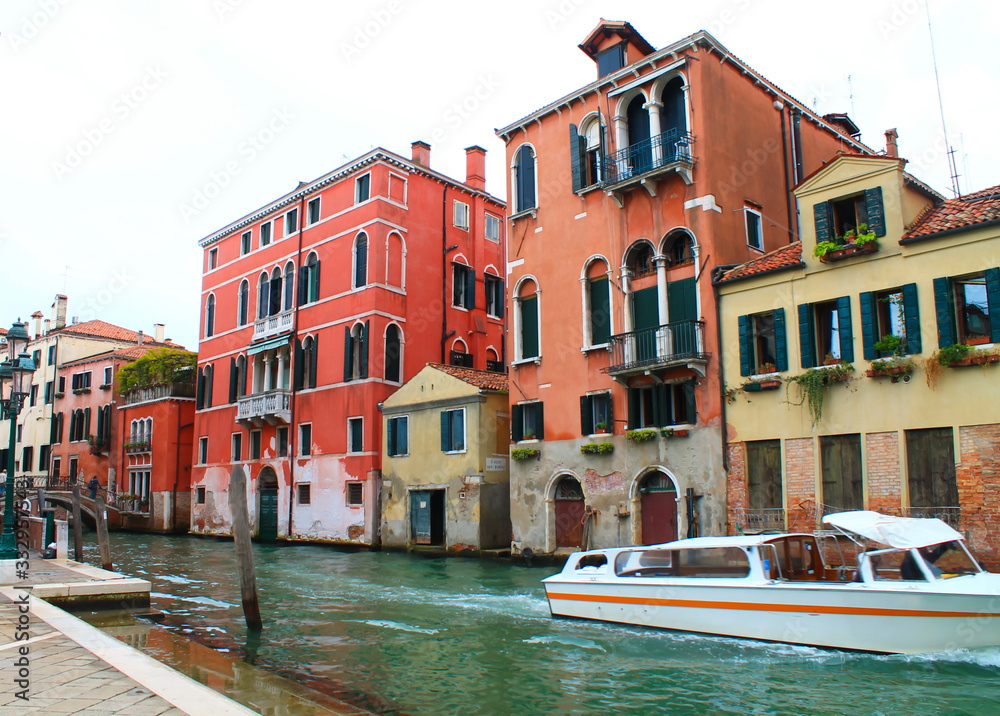 View of Venetian houses and a floating boat along the canal
