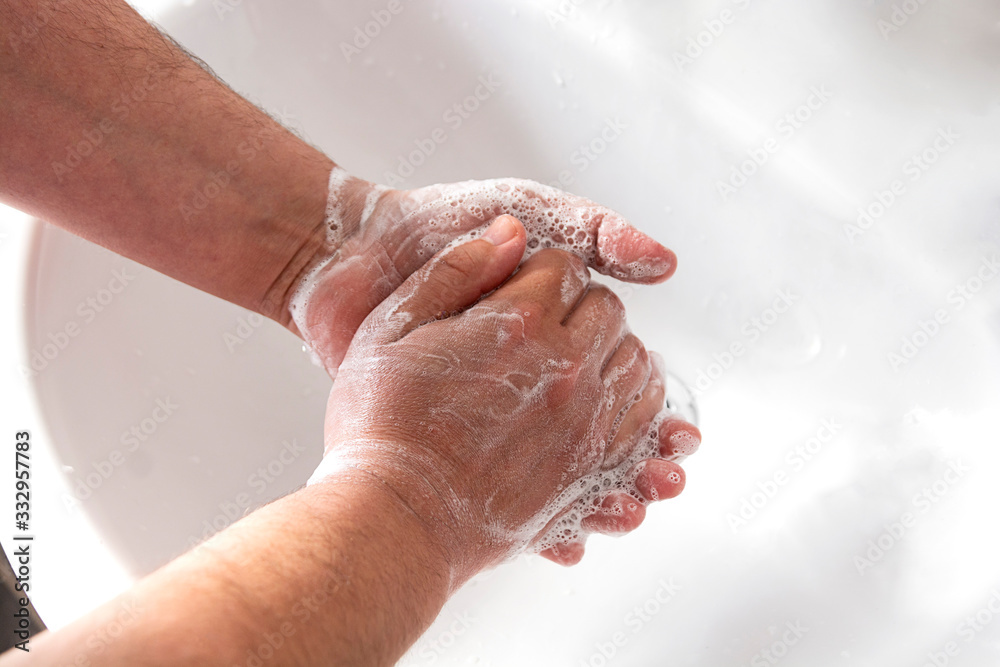 Man's hand wash his hands over sink in bathroom. Man's hand wash his hands over sink in bathroom.