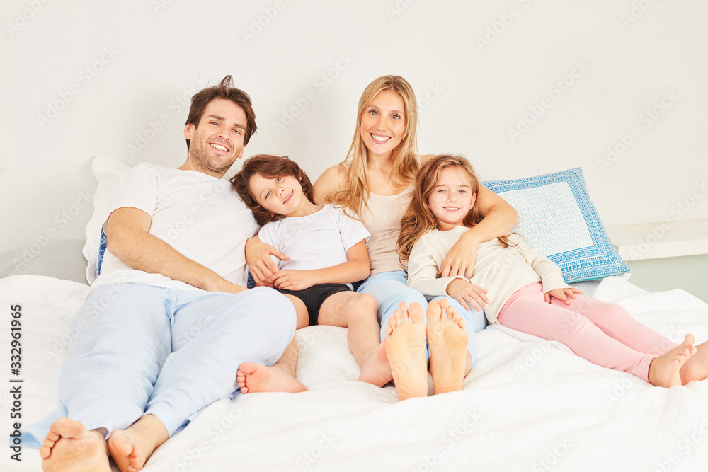 Familie mit zwei Kindern im Schlafanzug im Bett Familie mit zwei Kindern im Schlafanzug im Bett