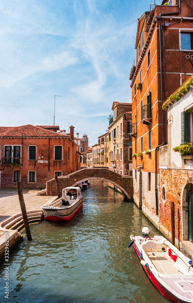 Venice, Italy. Narrow canal with residential buildings of the Venetian district of Santa Croce in the summer morning. The inscriptionin italian: Ponte di Ruga Vecchia - Old fold Bridge.