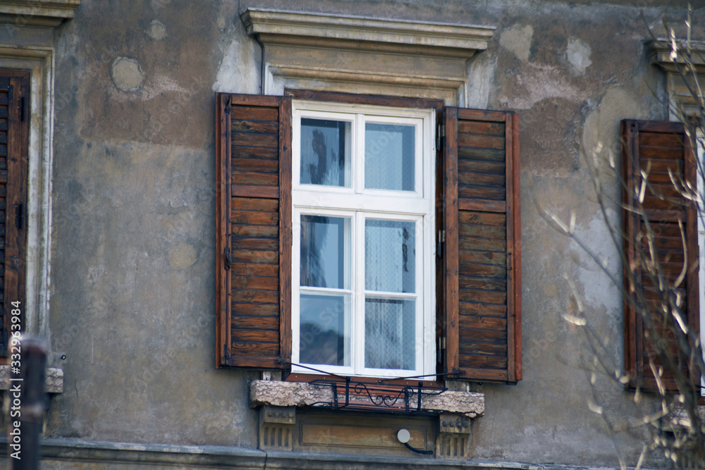 Obraz premium Italian window on the old wall facade with open wooden shabby brown paint shutters