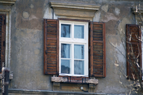 Italian window on the old wall facade with open wooden shabby brown paint shutters