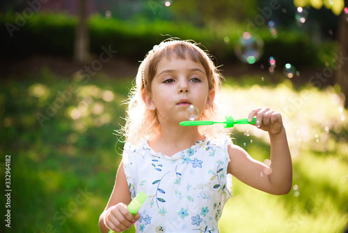 Girl with bubbles at a sunny summer evening