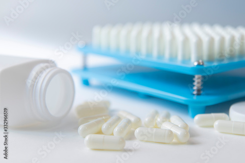 White pill capsules lay on floor near white bottom