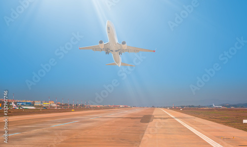 White Passenger plane fly up over take-off runway from airport 