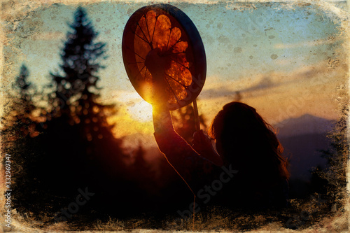 beautiful shamanic girl playing on shaman frame drum in the nature, old photo effect Fototapete