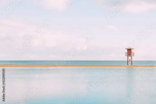 Relaxing deserted beach with lifeguard tower. The water flooded the sandy area.Enjoy the life Copy space.Travel, tourism, holiday concept.