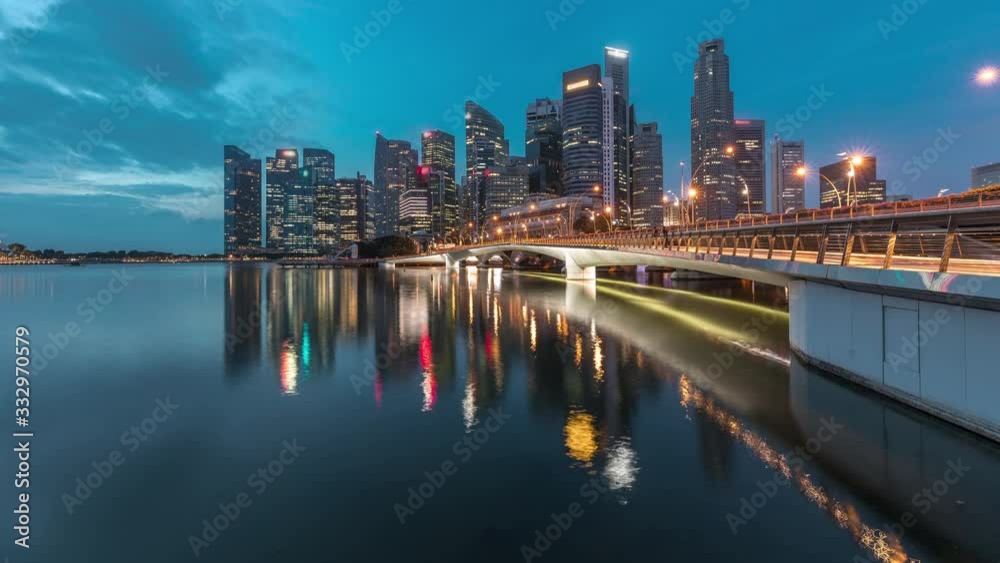 Esplanade bridge and downtown core skyscrapers in the background Singapore night to day transition timelapse. Illuminated towers reflected in water Esplanade bridge and downtown core skyscrapers in the background Singapore night to day transition timelapse. Illuminated towers reflected in water
