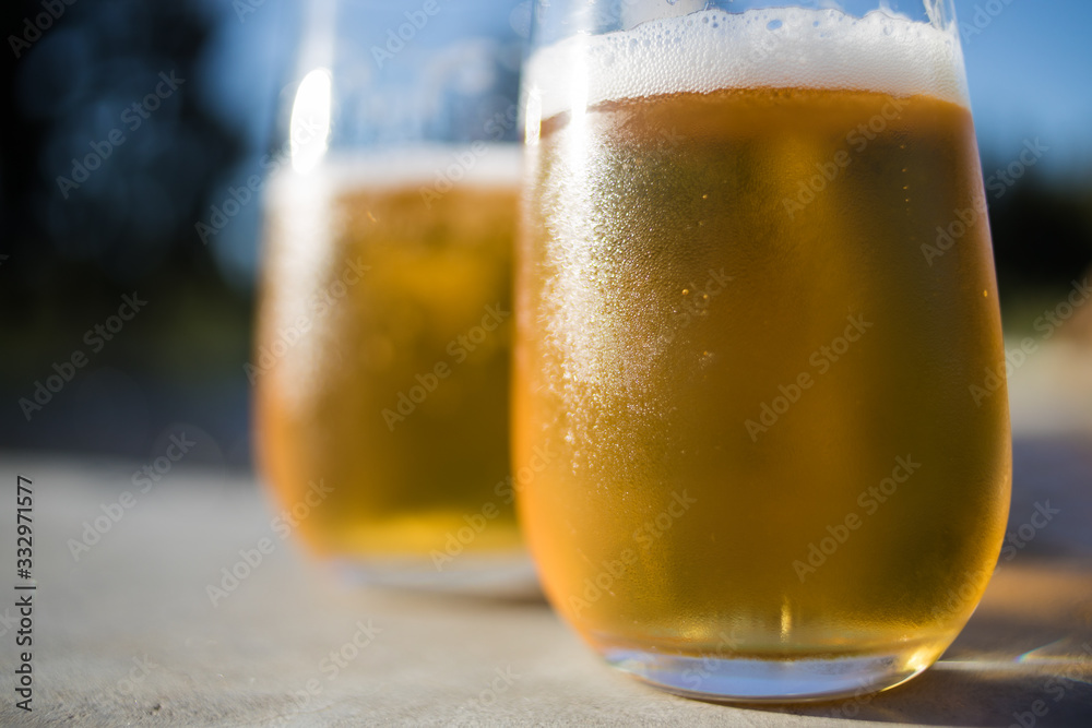 Close up image of two cold beers on a warm summer day next to the pool Close up image of two cold beers on a warm summer day next to the pool
