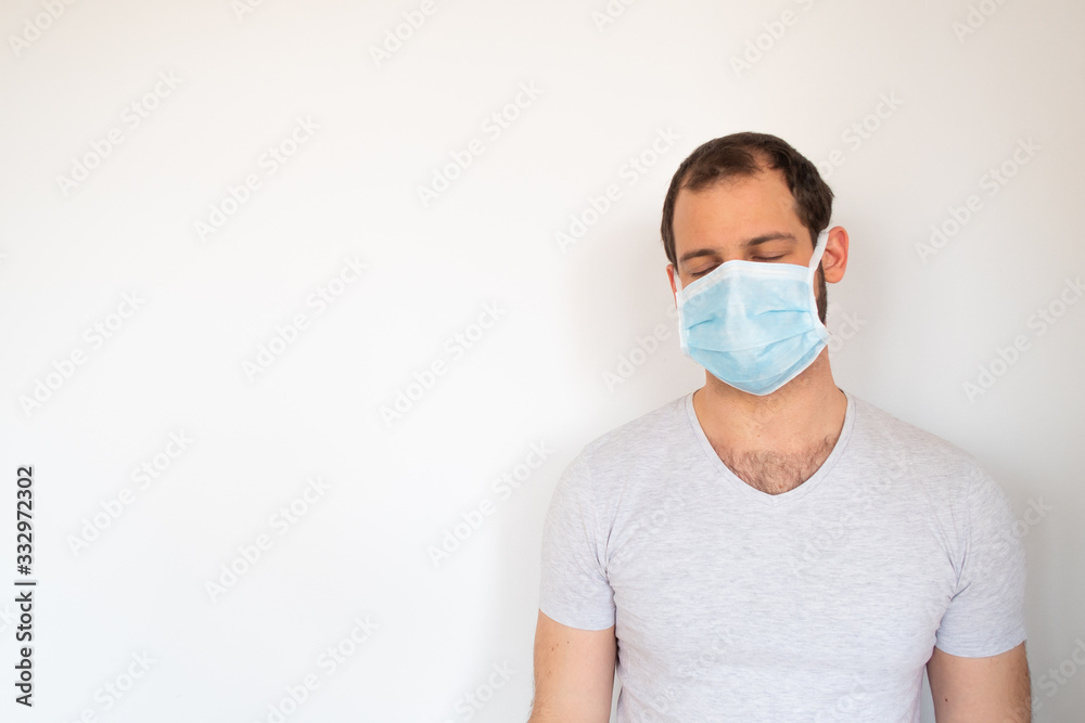 Close up view of a young man wearing a biomedical mask and closing his eyes during the pandemic crisis Close up view of a young man wearing a biomedical mask and closing his eyes during the pandemic crisis