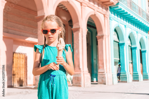 Adorable little girl eating ice-cream in popular area in Old Havana, Cuba.