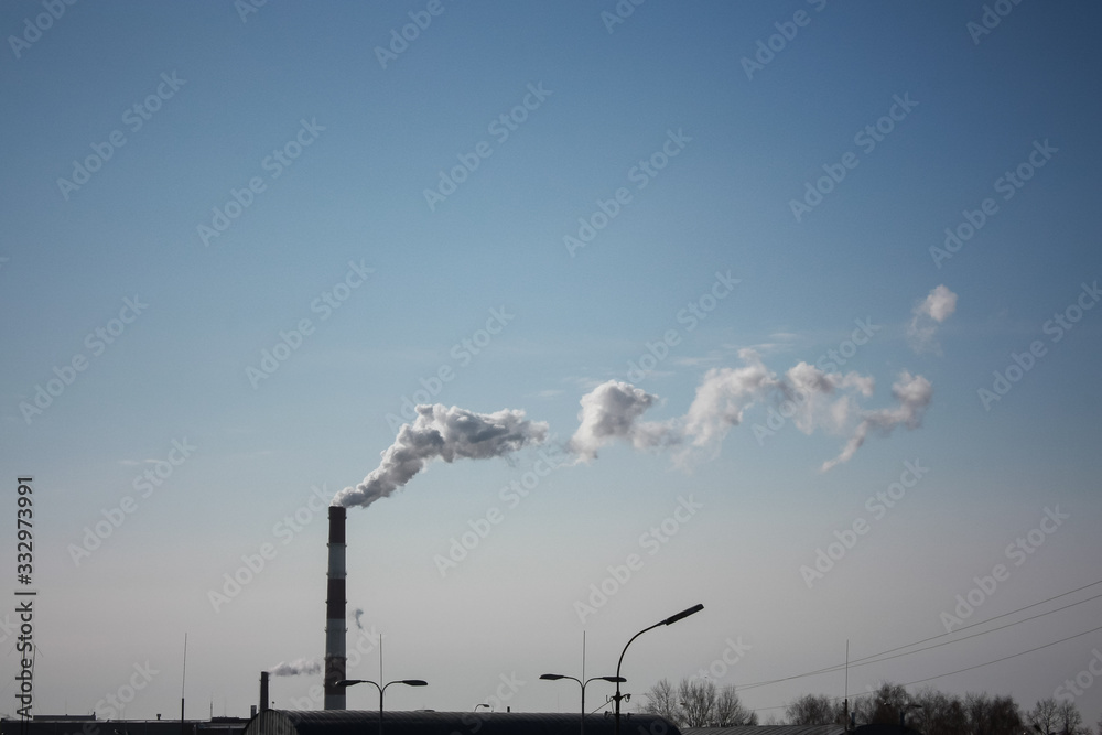 steam smoke coming from a chimney in an industrial zone on the outskirts of a city steam smoke coming from a chimney in an industrial zone on the outskirts of a city