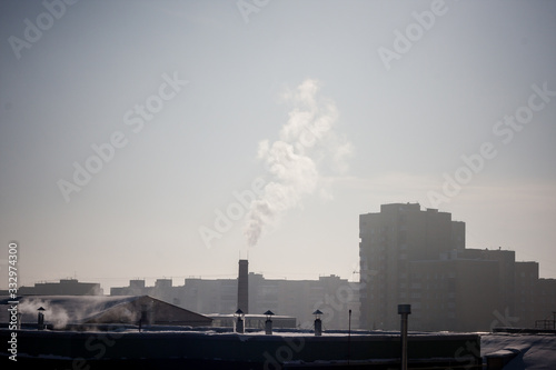 steam smoke coming from a chimney in an industrial zone on the outskirts of a city © KseniyaK
