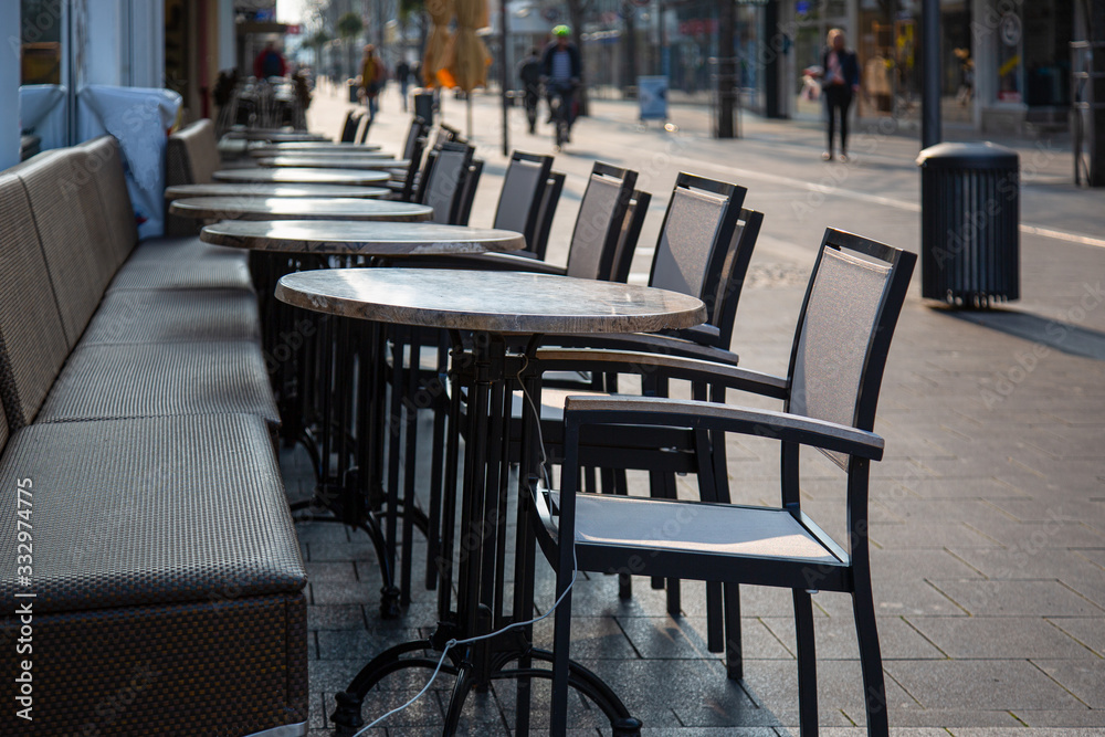 Neuwied, Germany - March 20, 2020: tables and chairs in front of a  closed shop in the city center of Neuwied based on Corona pandemic