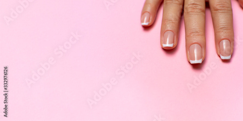 female fingers with a beautiful manicure on a pink background. high resolution widescreen image