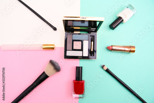 Set of makeup cosmetic: shadows, brushes, lipstick on background, top view