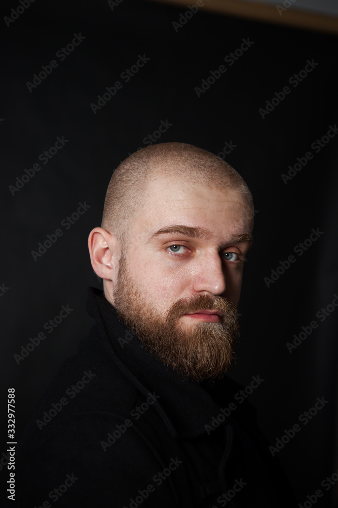 a mysterious portrait of a man with a beard on a black background with a small amount of light