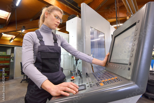 A young woman works as a computerized  numerical control engineer. She is seen at her workplace wearing a blue overall. 