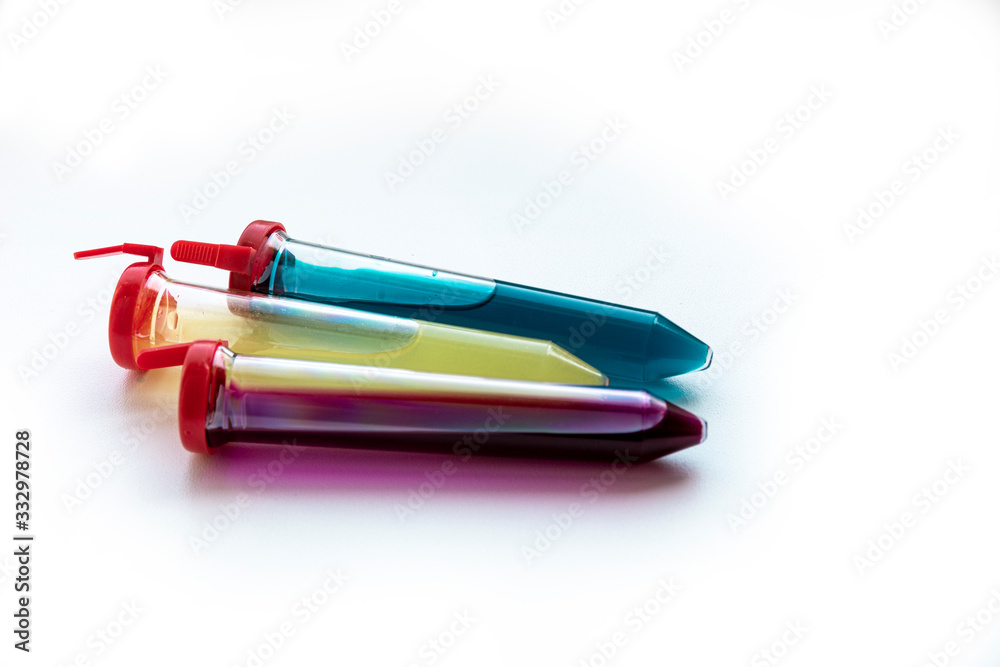Three test tubes with red, yellow and blue liquid on a white background. Three test tubes with red, yellow and blue liquid on a white background.