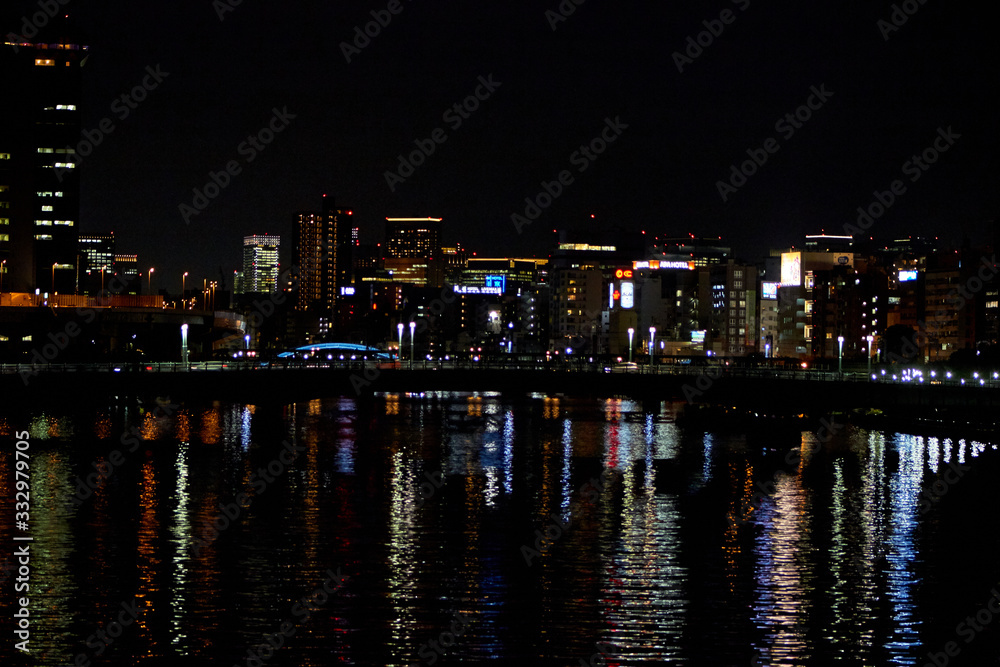 city buildings reflecting on the water at night