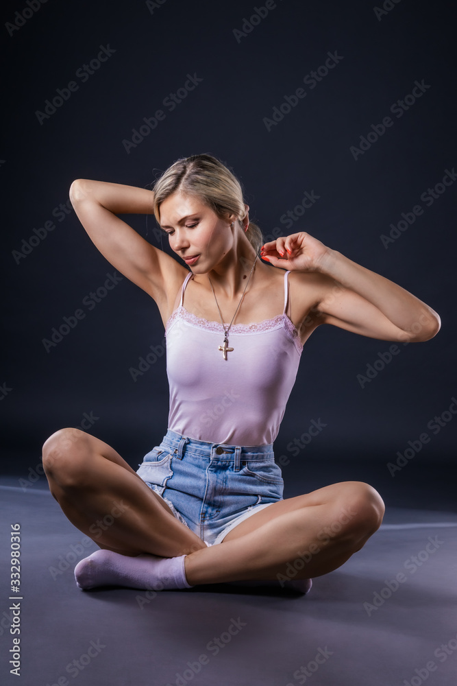 Relaxing young woman sitting on the floor in a bewitching pose Relaxing young woman sitting on the floor in a bewitching pose