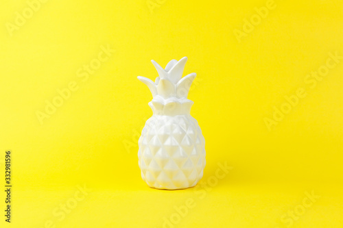 Trendy piece of interior white glossy ceramic pineapple on yellow paper background  copy space. Minimal style of decor concept. Horizontal. For lifestyle  interior blog  social media  poster